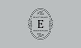 Premium monogram with the letter E. Frame with ornament. Luxury logo design with minimal modern font.