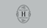Premium monogram with the letter H. Frame with ornament. Luxury logo design with minimal modern font.