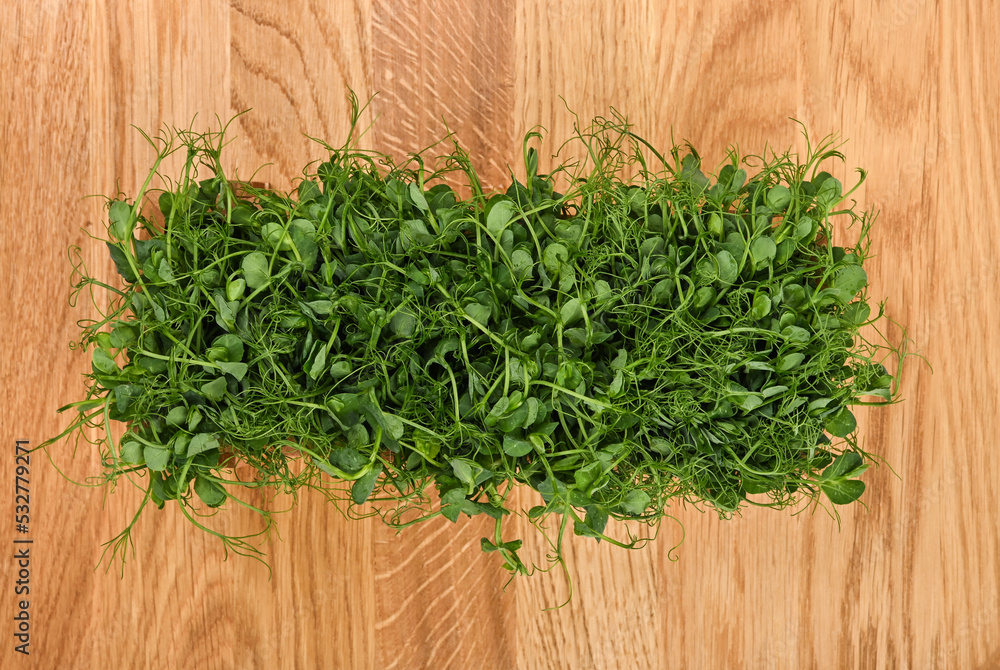 Green peas microgreen on wooden cutting board Green peas microgreen on wooden cutting board