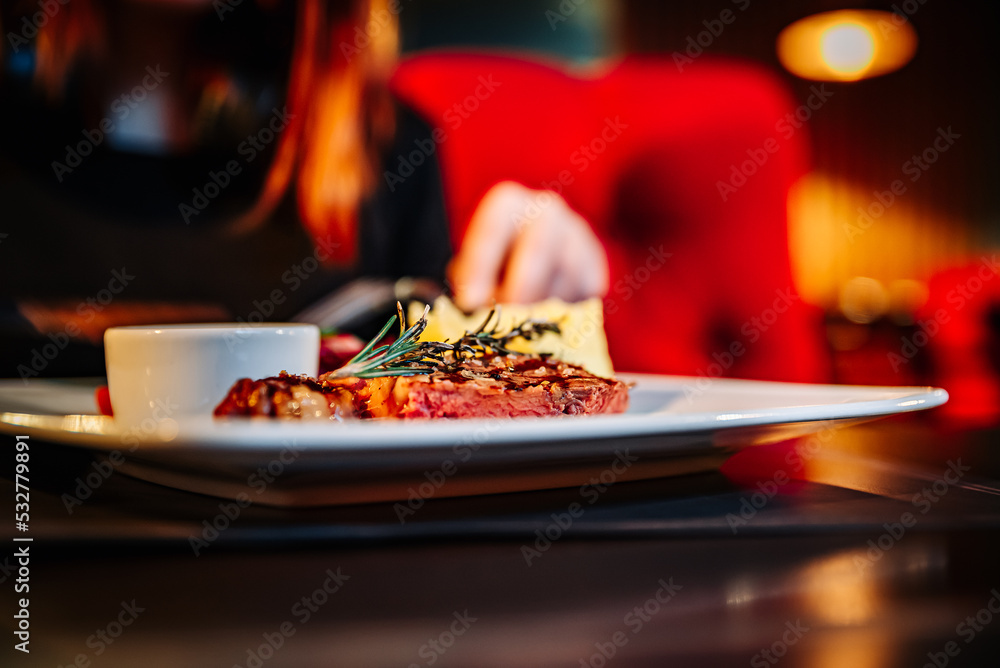 Fototapeta premium woman hands with fork and knife eating food in cafe