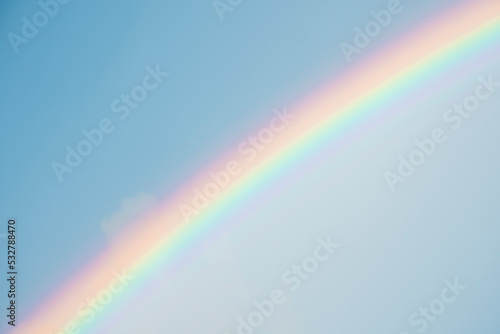 Beautiful view of rainbow amidst blue sky. Beautiful scenery of climatic environment on sunny day. Concept of idyllic nature.