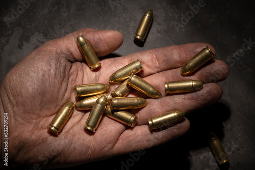 9mm pistol cartridges in the palm of a man. © Show_low