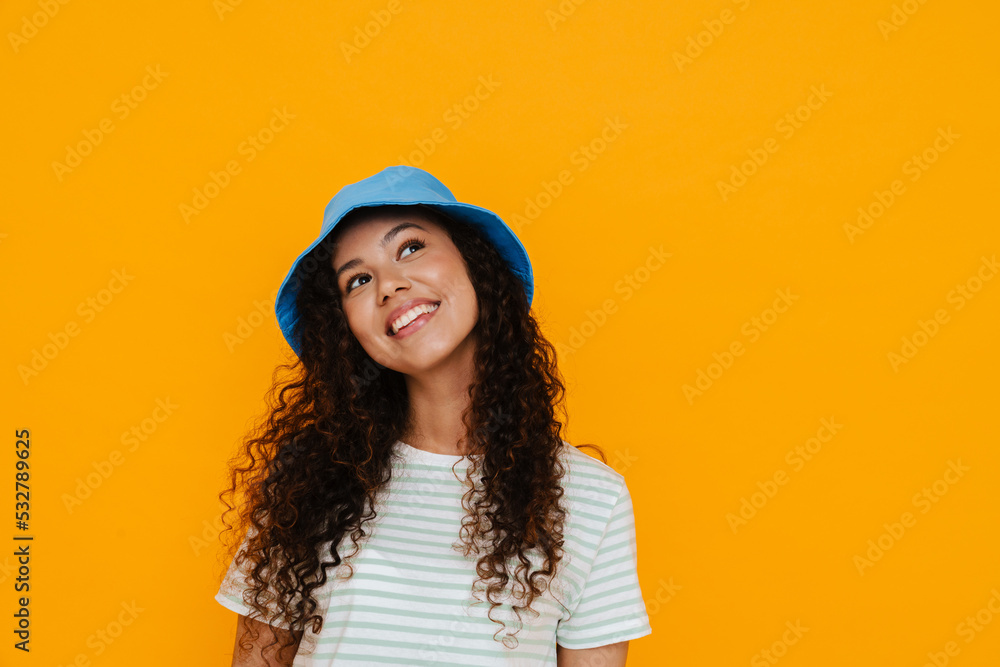 White curly woman wearing panama smiling while posing on camera