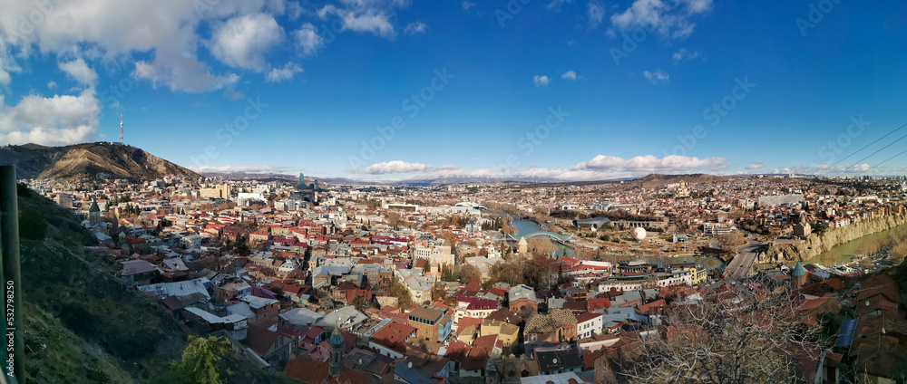 Panorama of Tbilisi. The capital of Georgia on a sunny day from a bird's eye view. Old city with buildings and river. Historic European city