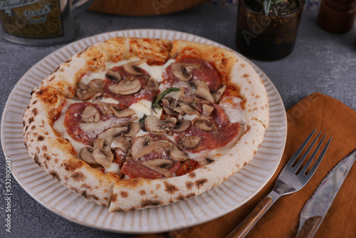 Dinner with Neapolitan pizza with sausage and mushrooms