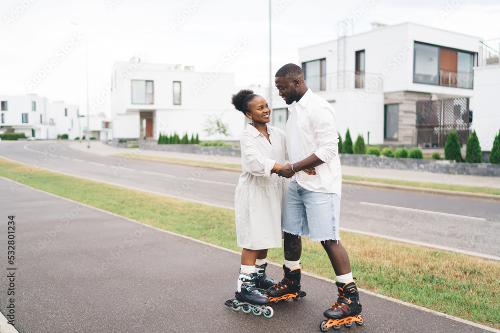 Happy ethnic couple in roller skates hugging on street Stock Photo | Adobe  Stock