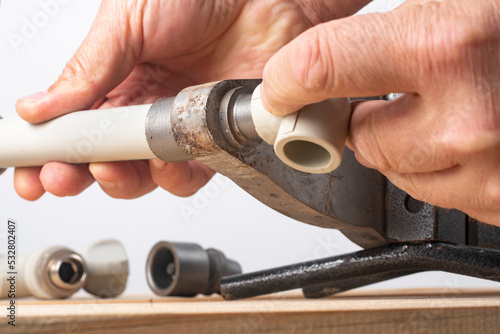 A worker is soldering polypropylene pipes.