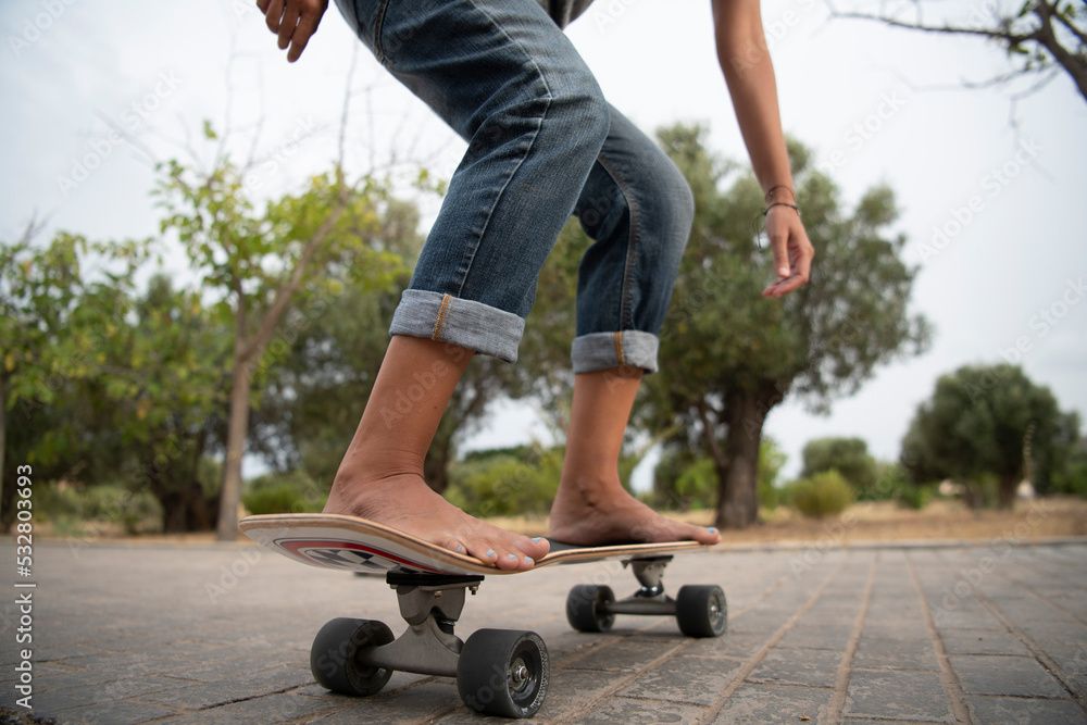 Barefoot girl with nail polish on her nails skates on the asphalt Barefoot girl with nail polish on her nails skates on the asphalt