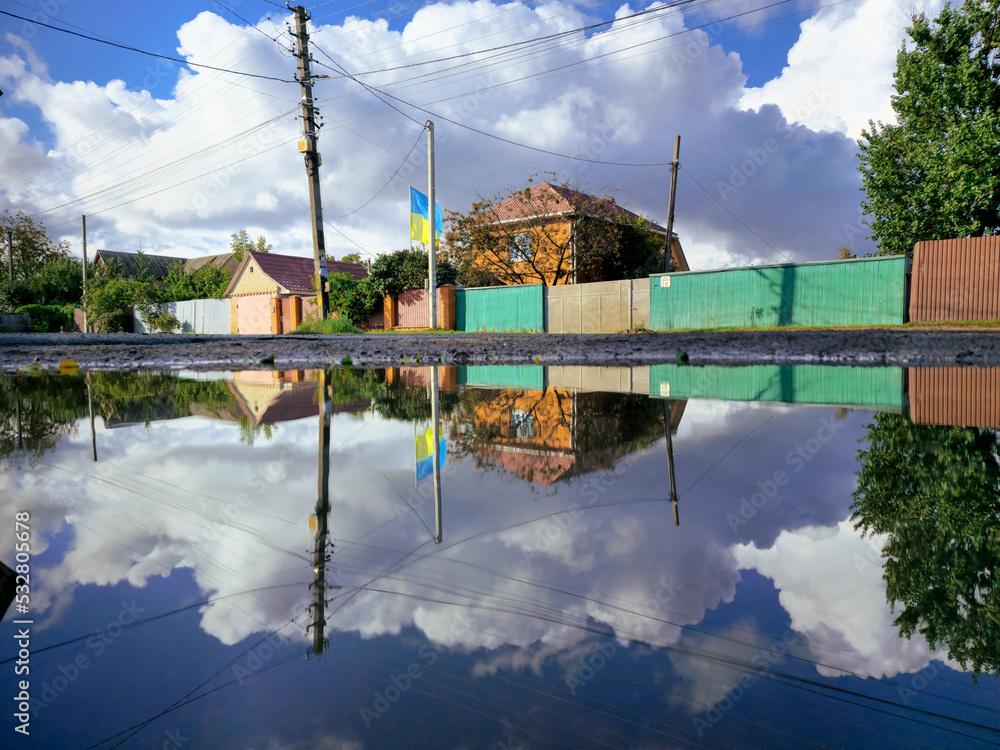 Ukrainian village. Private houses of a small Ukrainian village. Houses behind a large puddle