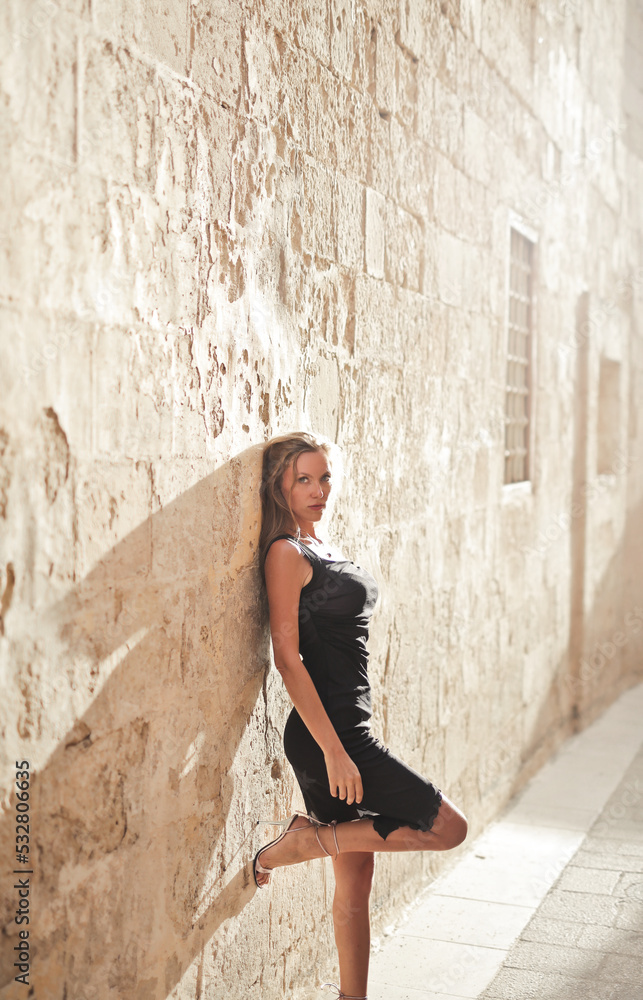 beautiful model leaning against a wall in mdina, malta