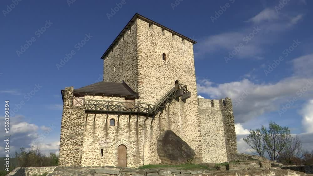 Beautiful time lapse shot of a medieval tower of Vrsac on top of a hill with clouds passing by in the distance on a warm autumn day within the golden hour of the day Beautiful time lapse shot of a medieval tower of Vrsac on top of a hill with clouds passing by in the distance on a warm autumn day within the golden hour of the day