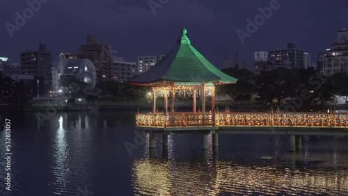 fukuoka, kyushu - december 06 2021: Pan video of the illuminated Ukimi-do Pavilion at night on the outer moat of Fukuoka Castle renamed Ohori Park depicting West Lake of China in Zhejiang Province. photo