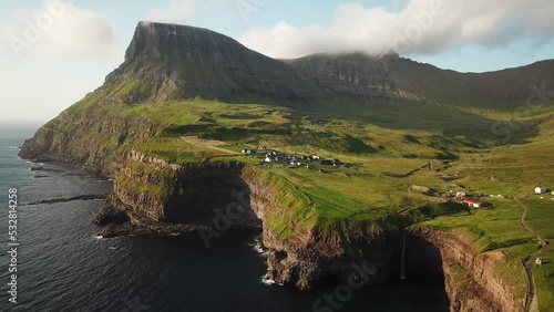 Wallpaper Mural Aerial drone view of Mulafossur waterfall, Faroe Islands. Small village Gasadalur with a Hvannadalur valley and Arnafjall mountain hidden in a fog. Sunny day in summer. High quality 4k footage. Torontodigital.ca