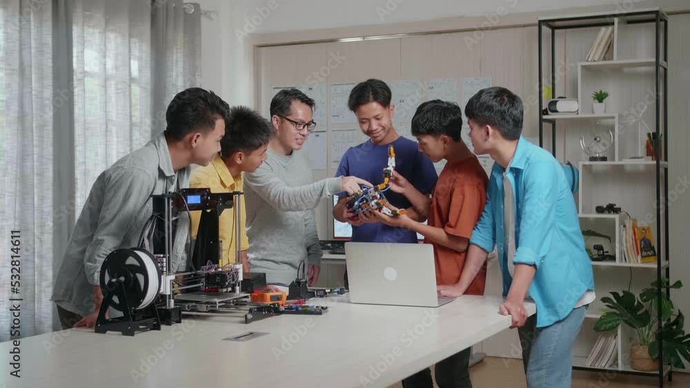 Asian Man With A Laptop And 3D Printing Teaching The Boys Assembling A Cyborg Hand Before Celebrating The Success At School
Asian Man With A Laptop And 3D Printing Teaching The Boys Assembling A Cyborg Hand Before Celebrating The Success At School