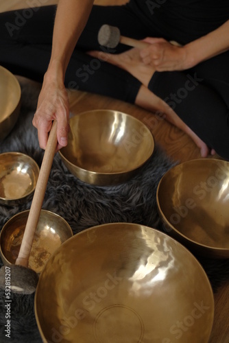 Women using singing copper bowl. Yoga, relaxation and meditation. Sound therapy, alternative medicine