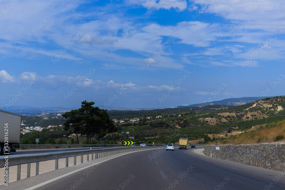 Fototapeta premium Highway wide road, transport and blue sky with clouds on a summer day