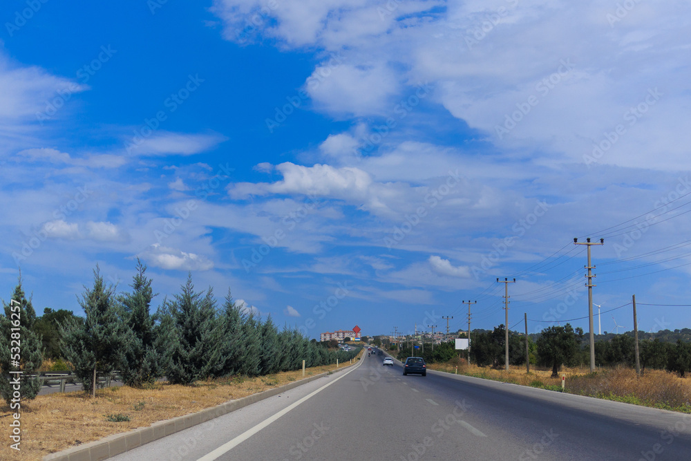 Fototapeta premium Highway wide road, transport and blue sky with clouds on a summer day
