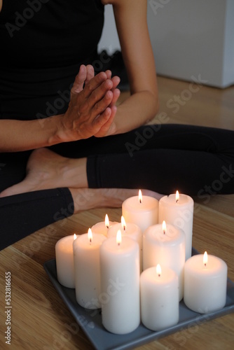 Women's hands light candles with matches. Yoga practice and fire in the palms