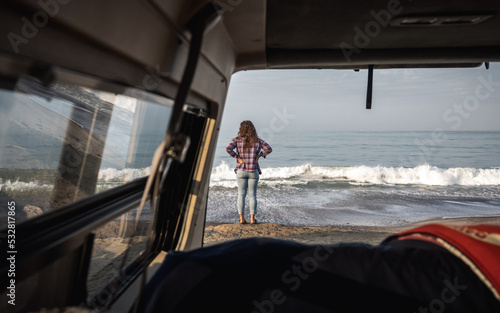 Woman Looking at Beach through Vintage Van