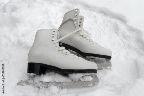 close-up of figure skates on an snow background. Ice skating outdoor activities.