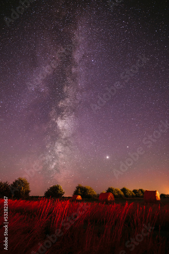 Traces Of Meteors On Night Sky. Natural Real Night Sky Stars With Milky Way Over Field Meadow After Harvest. Agricultural Colorful Background Copy Space.