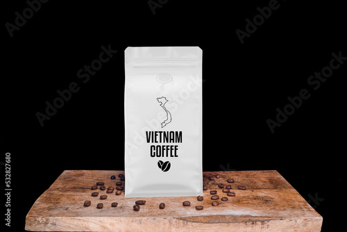 Vietnam coffee beans and white package on wooden board with black isolated background