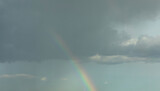 Rainbow on the background of a cloudy stormy sky. Banner. Nature.