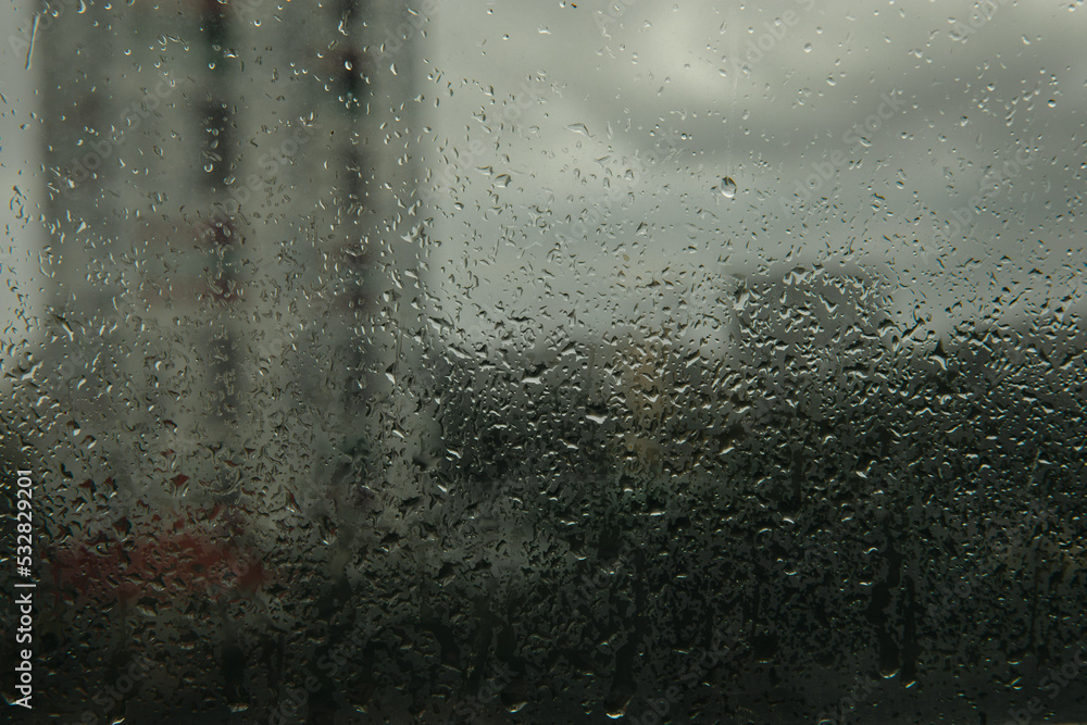 Glass with raindrops on the background of a thunderstorm. Raindrops on the background of the city.MOCKUP.Photo for design Glass with raindrops on the background of a thunderstorm. Raindrops on the background of the city.MOCKUP.Photo for design