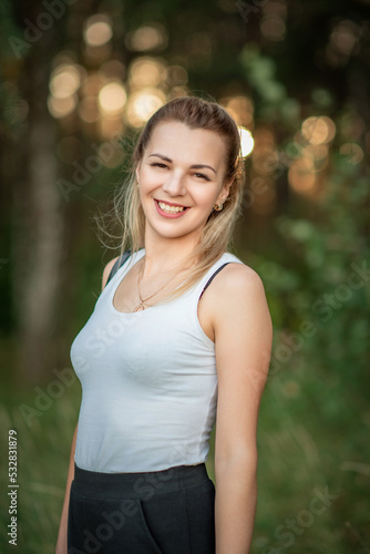 Fototapeta Naklejka Na Ścianę i Meble -  Portrait of a young beautiful girl in a light T-shirt in the forest.