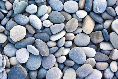 Abstract background with round pebble stones. Stones beach Top view.