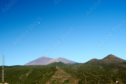 Teide with full moon and neighbouring green hills