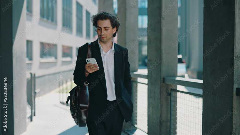 Businessman is going to the business centre, answering on the work chats on the social media. Male boss near his work place using smartphone, texting with clients. Businessman is going to the business centre, answering on the work chats on the social media. Male boss near his work place using smartphone, texting with clients.