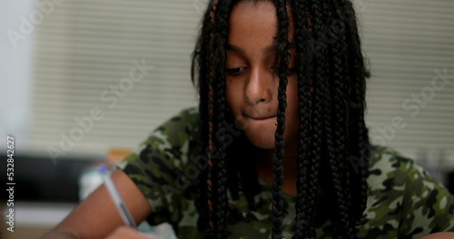 Fototapet Black girl writing notes doing homework. preteen child studying