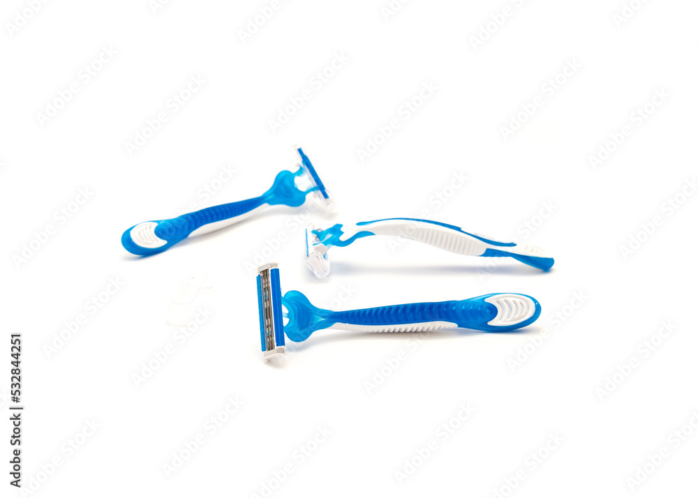 Three brand new blue and white plastic disposable razors with ergonomic handle isolated on white background Three brand new blue and white plastic disposable razors with ergonomic handle isolated on white background