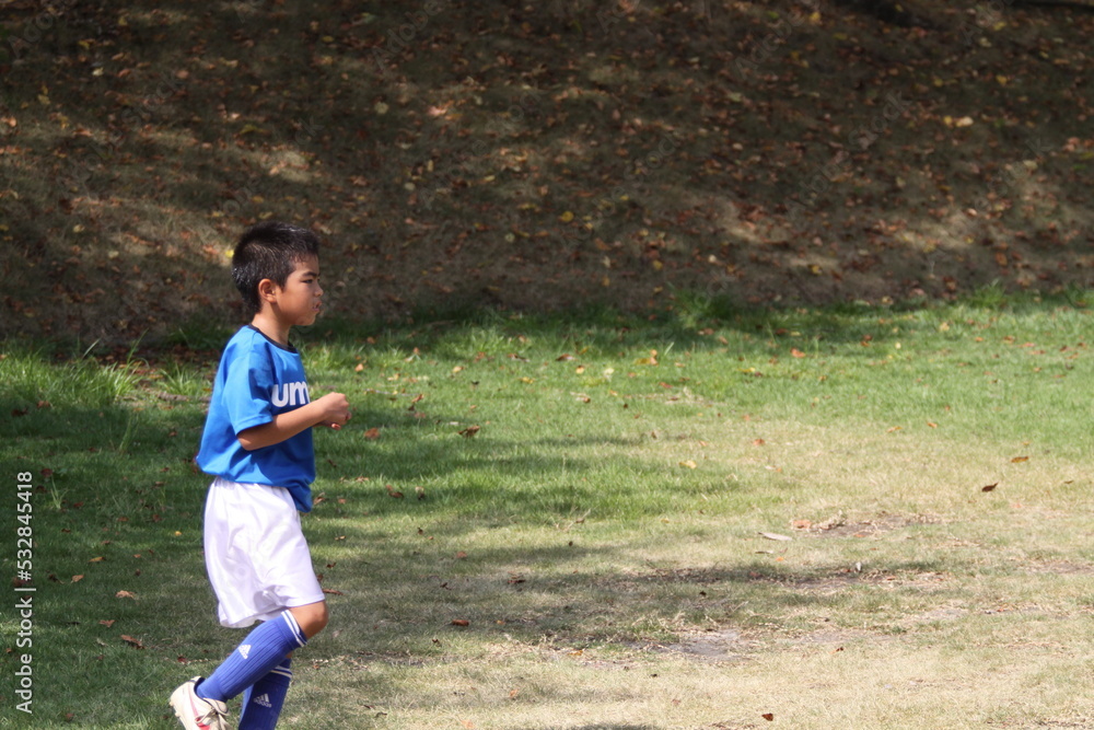 芝生でサッカーの練習をする子供 芝生でサッカーの練習をする子供