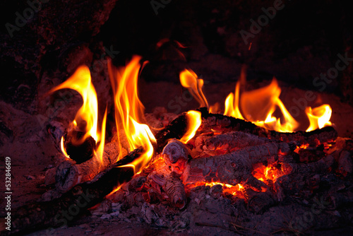 Romantic fireplace with a burning fire. Burning logs in fire. Flame of the fire warms and illuminates. 