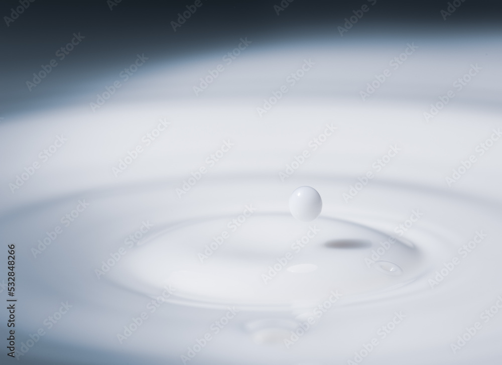 Closeup of drop of milk falling into milk bath Closeup of drop of milk falling into milk bath