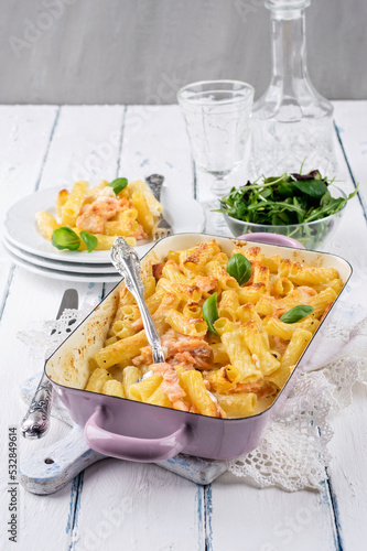 Traditional German pasta bake topped with salmon and cheese and served as a close-up in a shabby chic casserole dish photo