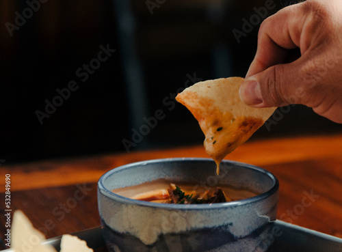 Dipping a Tortilla Chip into Queso photo