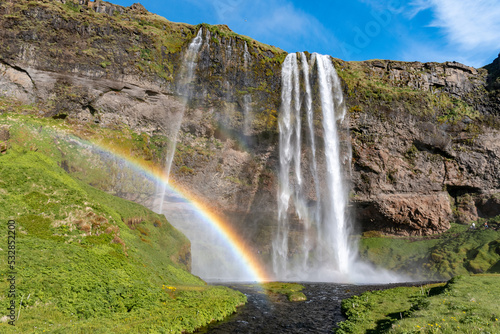 The waterfall Seljalandsfoss with a rainbow, famous landmark in southern Iceland