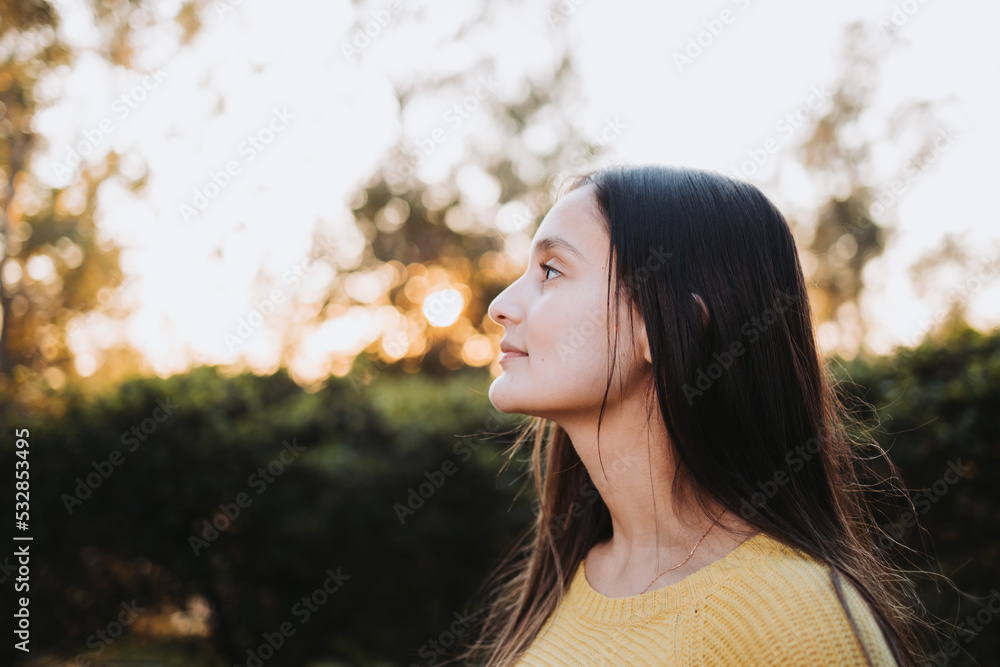 Serene young girl thinking in meaning of life and connecting with nature in the park. Overcoming depression Serene young girl thinking in meaning of life and connecting with nature in the park. Overcoming depression