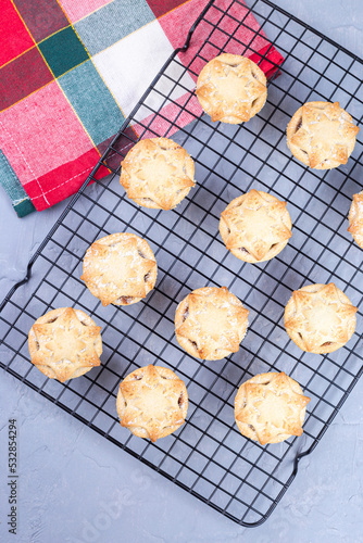 Traditional British Christmas mince pies or tarts with fruit filling, on a cooling rack, vertical, top view
