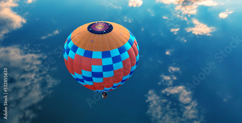 Hot air balloon over the blue sea. View from above