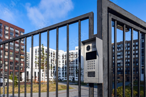 Electronic lock with buttons and intercom on the metal fence gate, safety device. photo