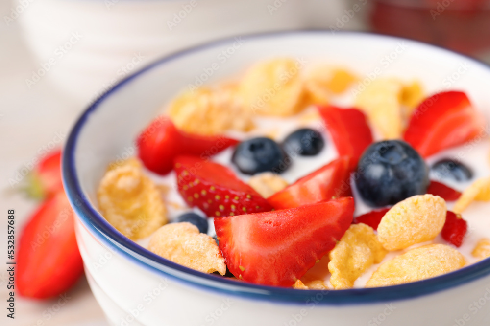 Bowl of tasty crispy corn flakes with milk and berries, closeup Bowl of tasty crispy corn flakes with milk and berries, closeup