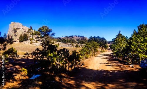 panoramic of rural zone with off road and some trees and a clear blue sky in creel chihuahua 