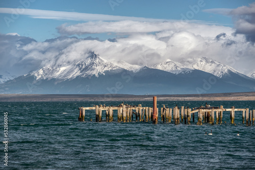 Braun & Blanchard pier in Puerto Natales with White-breasted Cormorants and mountain range in the background