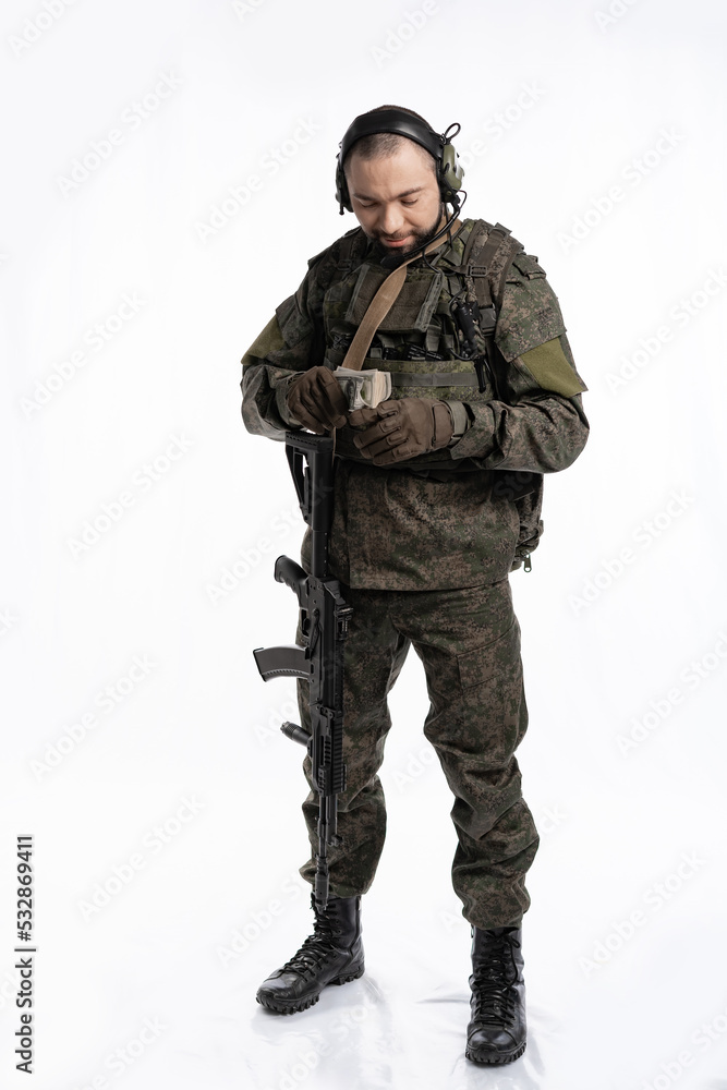 soldier in the studio on a white background. a man in military uniform with a rifle or machine gun. military or airball player