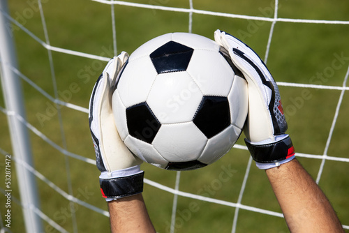 A Standard Classic black and white Outdoor Football Ball Soccer Ball catch by a goalkeeper