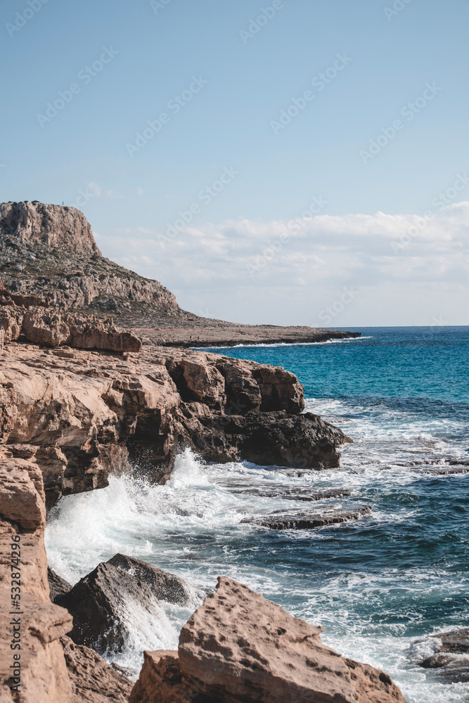 Beautiful seashore with lagoon sea and waves in front of the Cape Greco mountain